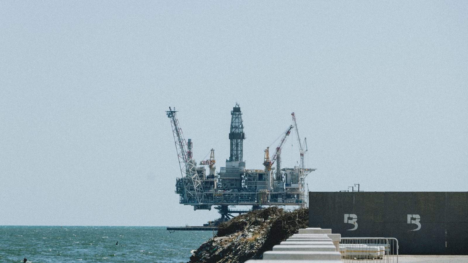 An oil platform standing beyond a seawall, not a photograph of the international accounts release.